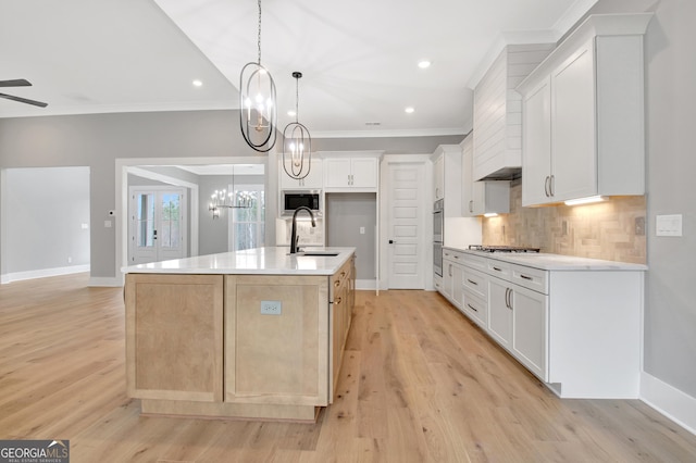 194 Forest Berry Ct Unit 98M2, Newnan, GA 30265 - kitchen with stainless steel appliances, crown molding, tasteful backsplash, light wood finished floors, and an island with sink