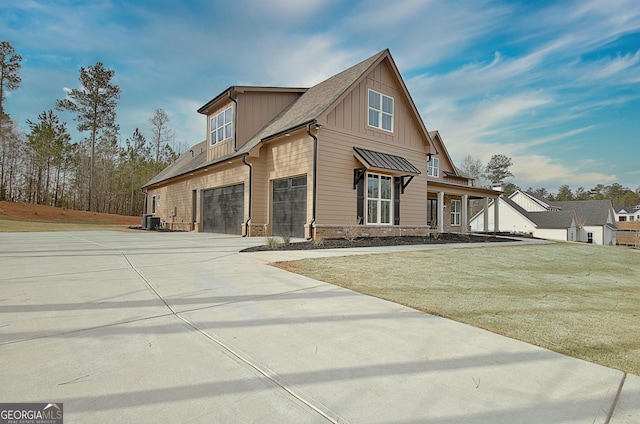 194 Forest Berry Ct Unit 98M2, Newnan, GA 30265 - view of side of home with board and batten siding, concrete driveway, an attached garage, stone siding, and a yard