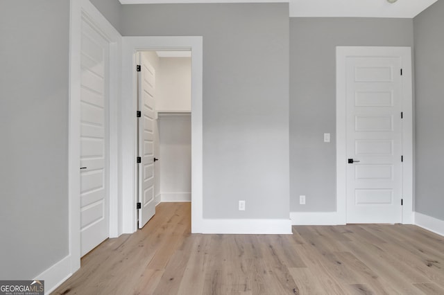 194 Forest Berry Ct Unit 98M2, Newnan, GA 30265 - unfurnished bedroom featuring light wood finished floors, a spacious closet, and a closet