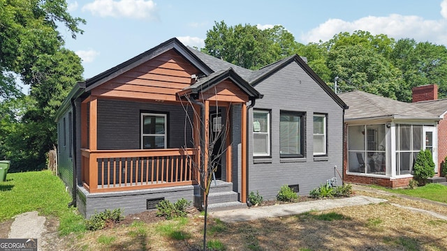 524 Paines Ave NW, Atlanta, GA 30318 - view of front facade featuring crawl space, a sunroom, a front yard, a chimney, and a porch