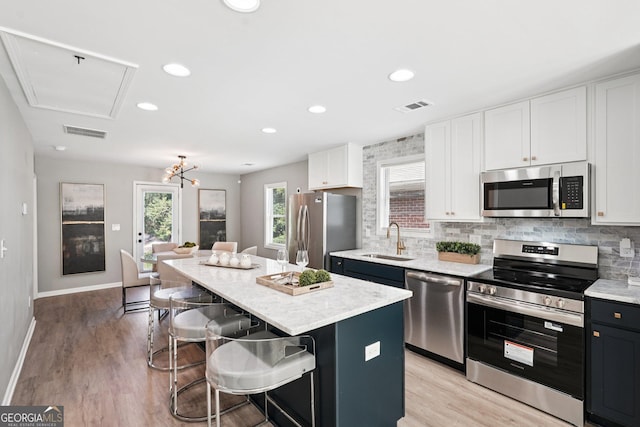 524 Paines Ave NW, Atlanta, GA 30318 - kitchen with appliances with stainless steel finishes, a center island, a kitchen bar, backsplash, and recessed lighting