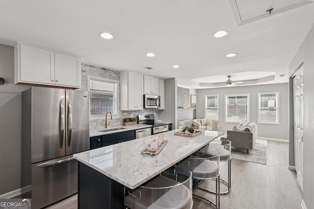 524 Paines Ave NW, Atlanta, GA 30318 - kitchen with appliances with stainless steel finishes, a breakfast bar area, recessed lighting, light stone countertops, and light wood-style floors