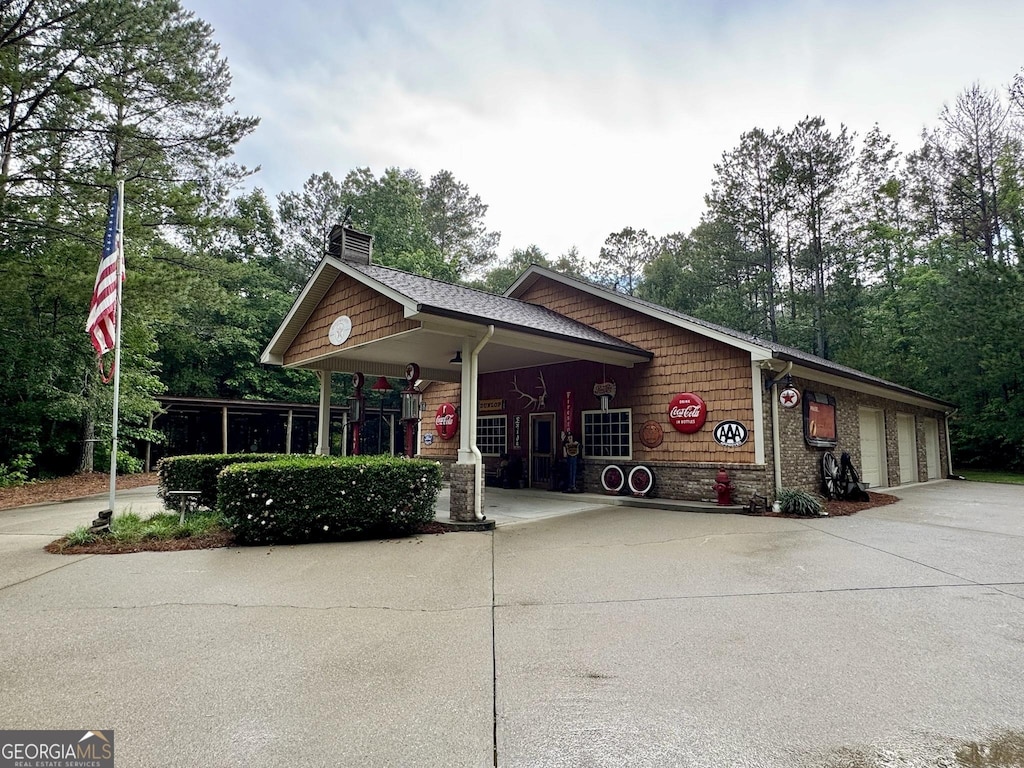 7970 Berea Rd, Winston, GA 30187 - view of front of house with concrete driveway, a chimney, and view of wooded area