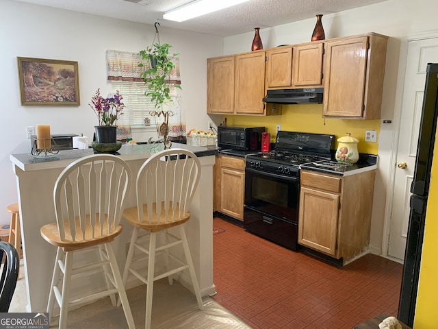 3232 Deer Pause Ln, Decatur, GA 30034 - kitchen with black appliances, under cabinet range hood, a breakfast bar area, and dark countertops