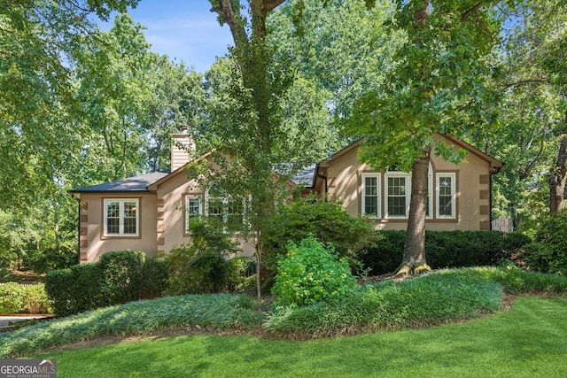 120 Timbervalley Ln, Lawrenceville, GA 30043 - view of front of property with a chimney, a front yard, and stucco siding