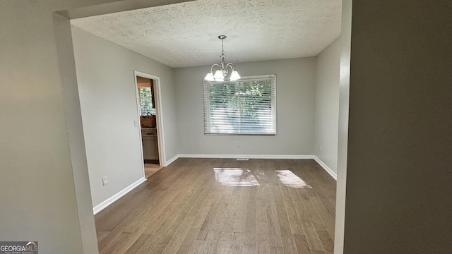 4550 Cypress Ridge Ct, Stone Mountain, GA 30083 - unfurnished dining area with a chandelier, wood finished floors, and a textured ceiling