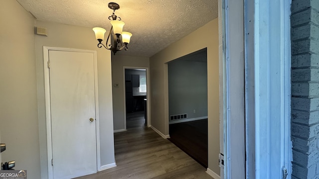 4550 Cypress Ridge Ct, Stone Mountain, GA 30083 - hallway with wood finished floors, a chandelier, and a textured ceiling