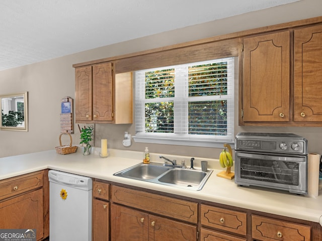 2866 Rosecommons Dr, Hampton, GA 30228 - kitchen featuring dishwasher, light countertops, and brown cabinetry