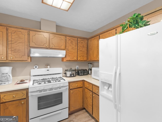 2866 Rosecommons Dr, Hampton, GA 30228 - kitchen featuring white appliances, under cabinet range hood, light countertops, and light wood-style flooring