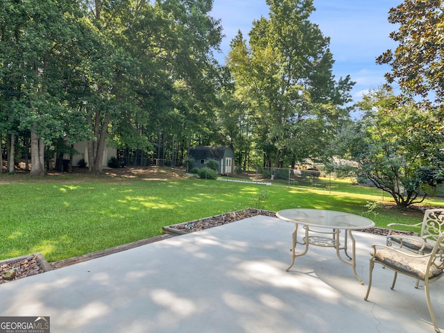 2866 Rosecommons Dr, Hampton, GA 30228 - fenced backyard with a patio area, a storage unit, and view of wooded area