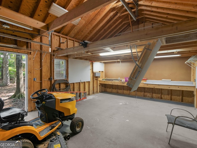 2866 Rosecommons Dr, Hampton, GA 30228 - miscellaneous room featuring lofted ceiling, a garage, and unfinished concrete flooring