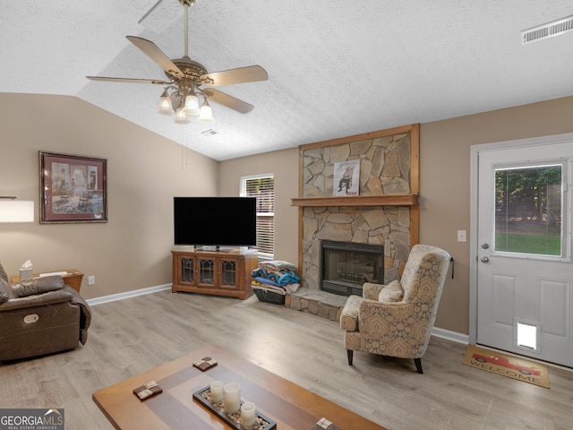 2866 Rosecommons Dr, Hampton, GA 30228 - living area with wood finished floors, a textured ceiling, lofted ceiling, a ceiling fan, and a fireplace