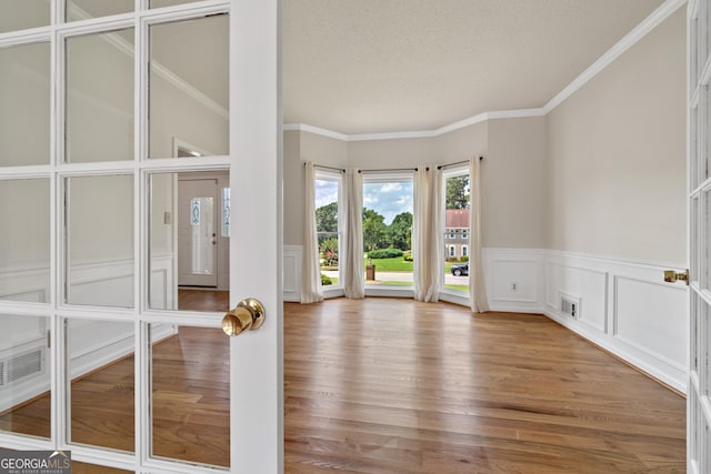 11 Chad Ct, Mcdonough, GA 30253 - spare room with wainscoting, a decorative wall, wood finished floors, crown molding, and a textured ceiling