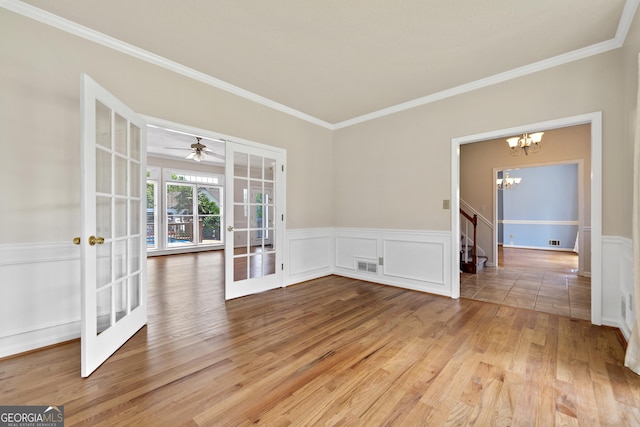 11 Chad Ct, Mcdonough, GA 30253 - empty room with french doors, a chandelier, crown molding, light wood-type flooring, and a ceiling fan