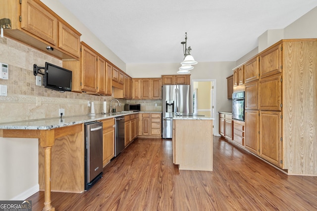 11 Chad Ct, Mcdonough, GA 30253 - kitchen featuring appliances with stainless steel finishes, dark wood-type flooring, backsplash, a kitchen island, and light stone countertops