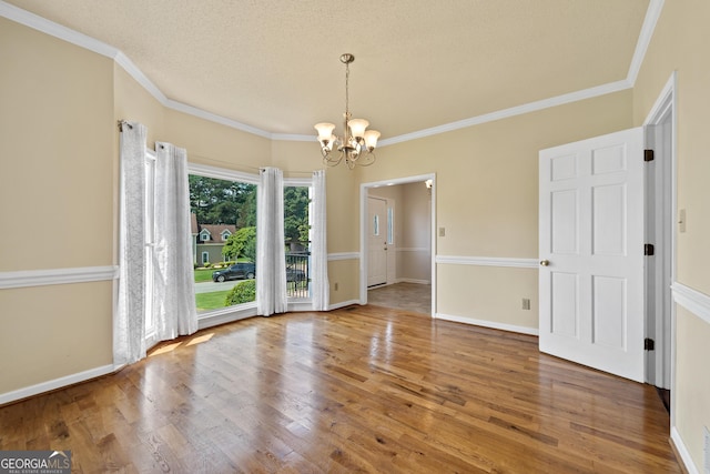 11 Chad Ct, Mcdonough, GA 30253 - empty room with a chandelier, crown molding, wood finished floors, and a textured ceiling