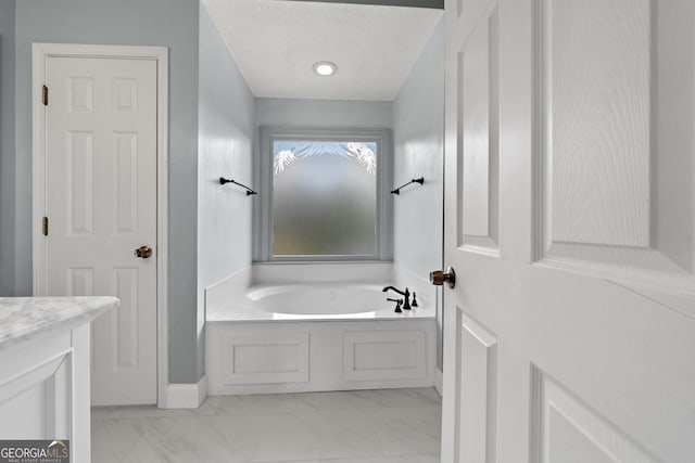 11 Chad Ct, Mcdonough, GA 30253 - bathroom featuring a bath, marble look tile flooring, vanity, and a textured ceiling