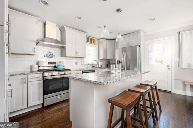 963 Turner Dr SE, Smyrna, GA 30080 - kitchen featuring appliances with stainless steel finishes, wall chimney exhaust hood, plenty of natural light, a kitchen bar, and crown molding