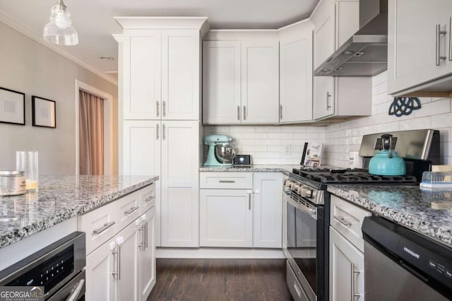 963 Turner Dr SE, Smyrna, GA 30080 - kitchen with wall chimney range hood, appliances with stainless steel finishes, ornamental molding, dark wood-type flooring, and decorative backsplash