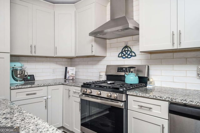963 Turner Dr SE, Smyrna, GA 30080 - kitchen featuring wall chimney exhaust hood, stainless steel appliances, light stone countertops, backsplash, and white cabinetry