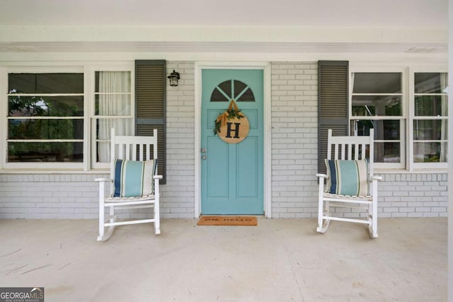 963 Turner Dr SE, Smyrna, GA 30080 - view of exterior entry featuring a porch and brick siding