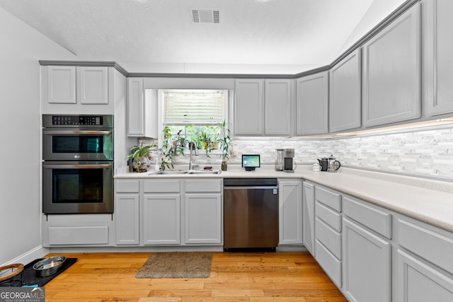 152 Bear Creek Rd, Moreland, GA 30259 - kitchen featuring stainless steel appliances, light wood-style floors, light countertops, and a textured ceiling