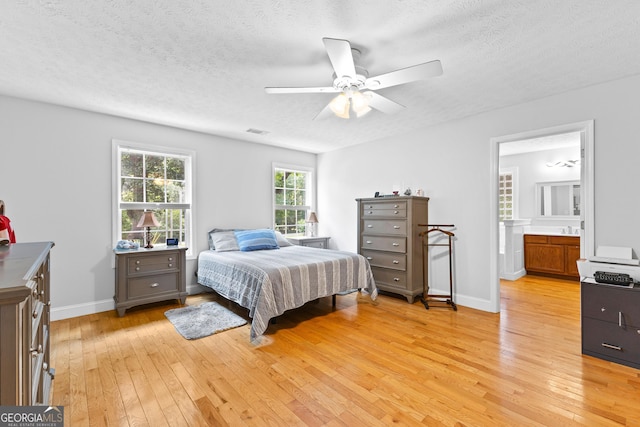 152 Bear Creek Rd, Moreland, GA 30259 - bedroom featuring light wood-style floors, a textured ceiling, connected bathroom, and a ceiling fan