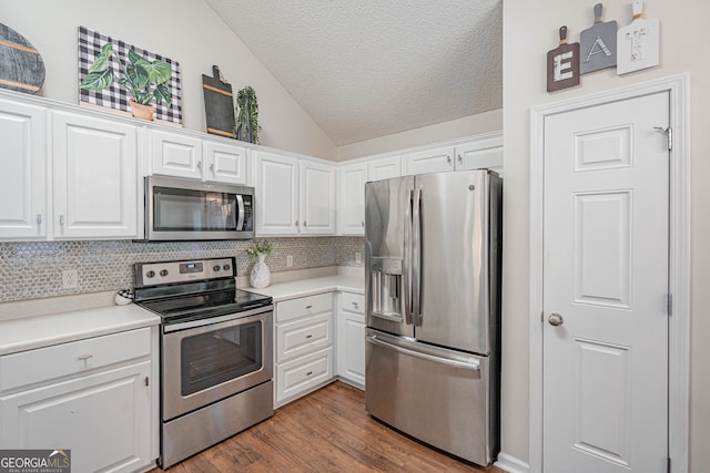 231 Brookstone Ct, Rincon, GA 31326 - kitchen featuring appliances with stainless steel finishes, vaulted ceiling, a textured ceiling, backsplash, and white cabinets