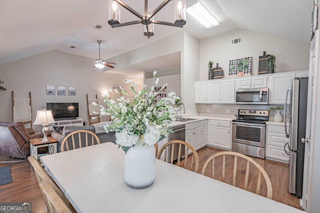 231 Brookstone Ct, Rincon, GA 31326 - dining room with vaulted ceiling, wood finished floors, a chandelier, and ceiling fan