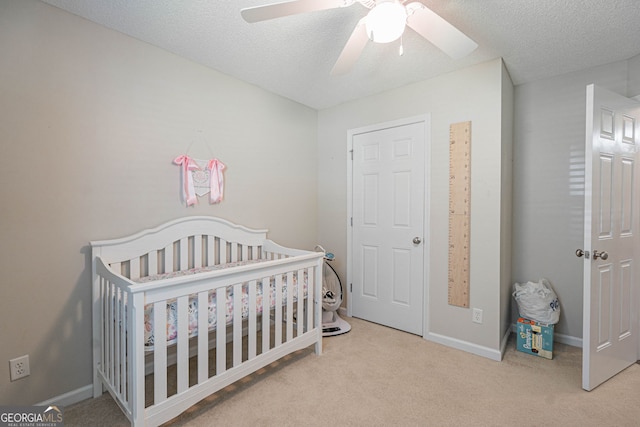 231 Brookstone Ct, Rincon, GA 31326 - carpeted bedroom featuring a crib, a textured ceiling, and a ceiling fan