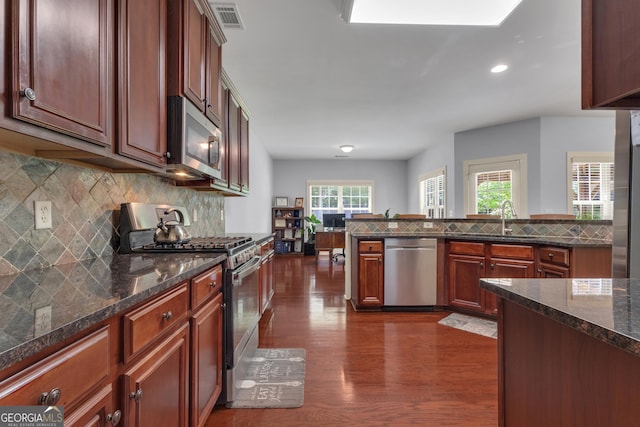 14 Hammock Ridge Dr, Newnan, GA 30265 - kitchen with appliances with stainless steel finishes, dark wood finished floors, recessed lighting, decorative backsplash, and dark stone countertops