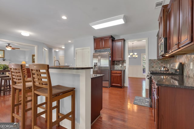 14 Hammock Ridge Dr, Newnan, GA 30265 - kitchen featuring stainless steel appliances, a kitchen bar, dark wood-style flooring, backsplash, and ceiling fan