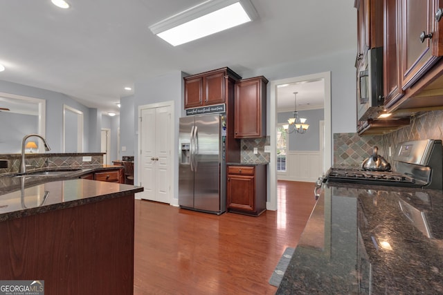 14 Hammock Ridge Dr, Newnan, GA 30265 - kitchen with stainless steel appliances, dark wood-type flooring, decorative backsplash, dark stone countertops, and ornamental molding