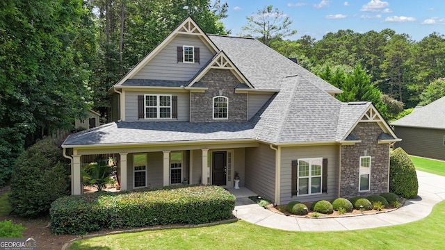 14 Hammock Ridge Dr, Newnan, GA 30265 - craftsman-style home featuring roof with shingles, a front lawn, stone siding, and a porch