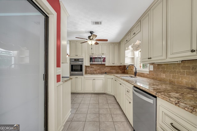234 Crumbley Rd, Mcdonough, GA 30252 - kitchen featuring stainless steel appliances, cream cabinetry, backsplash, a ceiling fan, and light tile patterned floors