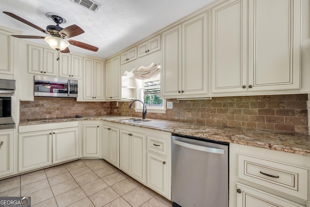 234 Crumbley Rd, Mcdonough, GA 30252 - kitchen featuring cream cabinetry, appliances with stainless steel finishes, light tile patterned flooring, backsplash, and a ceiling fan