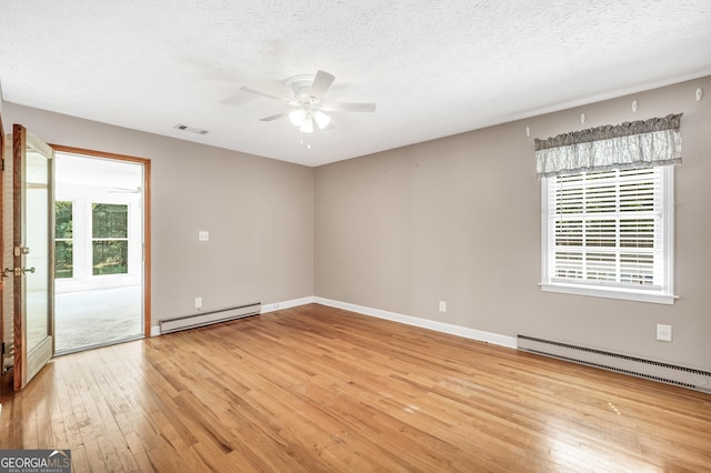 234 Crumbley Rd, Mcdonough, GA 30252 - spare room with a baseboard heating unit, ceiling fan, light wood-style floors, and a textured ceiling