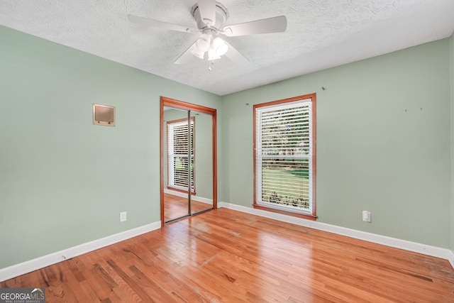 234 Crumbley Rd, Mcdonough, GA 30252 - unfurnished bedroom featuring wood finished floors, a textured ceiling, a closet, and ceiling fan