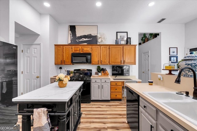 4385 Pinehollow Ct, Alpharetta, GA 30022 - kitchen with black appliances, light wood-style flooring, recessed lighting, decorative backsplash, and a kitchen island