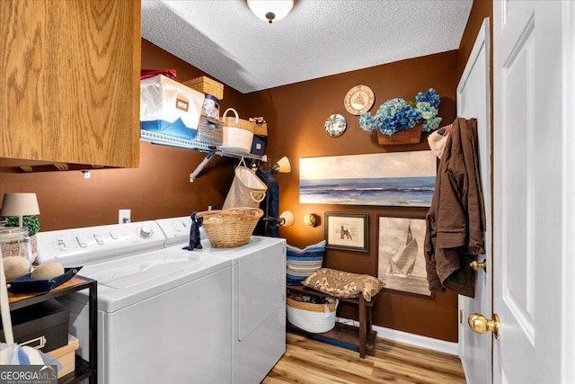 4385 Pinehollow Ct, Alpharetta, GA 30022 - laundry room featuring washer and clothes dryer, a textured ceiling, wood finished floors, and cabinet space