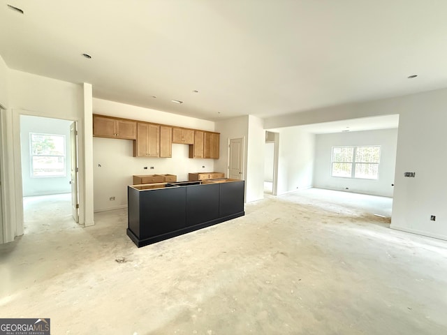 101 Everwood Ct, Dallas, GA 30132 - kitchen with open floor plan, a kitchen island, concrete floors, and brown cabinetry