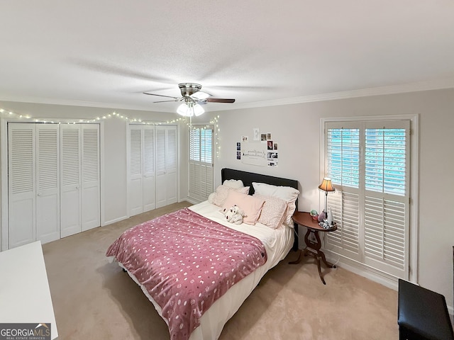 180 Broomsedge Trl, Athens, GA 30605 - carpeted bedroom with ornamental molding, two closets, and a ceiling fan