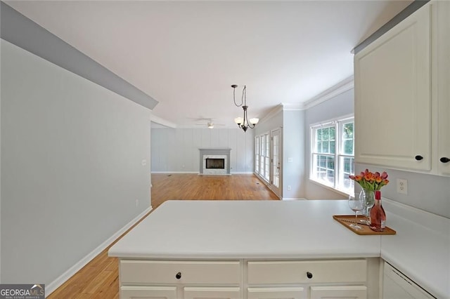 5176 Shotwell St, Woodstock, GA 30188 - kitchen with light wood-style flooring, a fireplace, ornamental molding, light countertops, and open floor plan