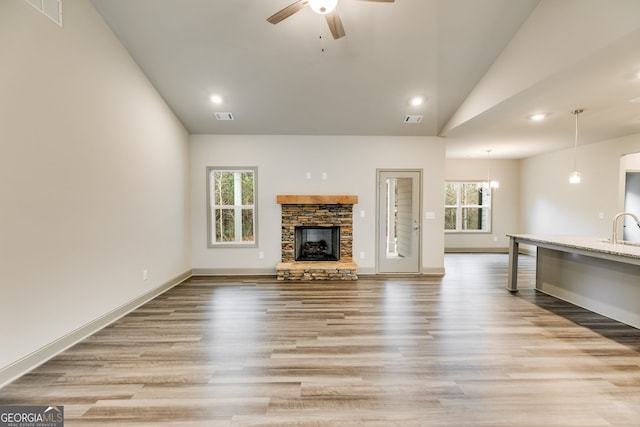 32 Sourwood Dr, Mansfield, GA 30055 - unfurnished living room with vaulted ceiling, ceiling fan, light wood-type flooring, a fireplace, and recessed lighting