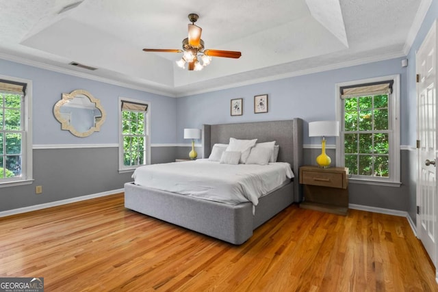 4961 Thornwood Trce NW, Acworth, GA 30102 - bedroom with a tray ceiling, multiple windows, wood finished floors, a ceiling fan, and crown molding