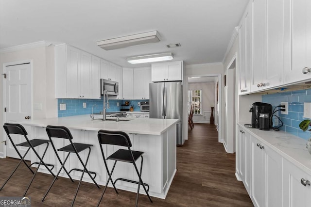 4961 Thornwood Trce NW, Acworth, GA 30102 - kitchen featuring appliances with stainless steel finishes, ornamental molding, a peninsula, a breakfast bar, and backsplash