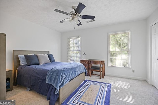 7045 Hunters Knl NE, Sandy Springs, GA 30328 - bedroom with multiple windows, light carpet, ceiling fan, and a textured ceiling