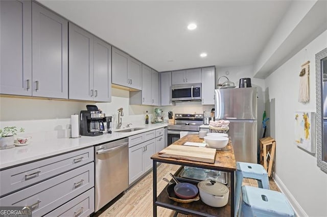 7045 Hunters Knl NE, Sandy Springs, GA 30328 - kitchen featuring stainless steel appliances, gray cabinetry, light countertops, recessed lighting, and light wood-style floors
