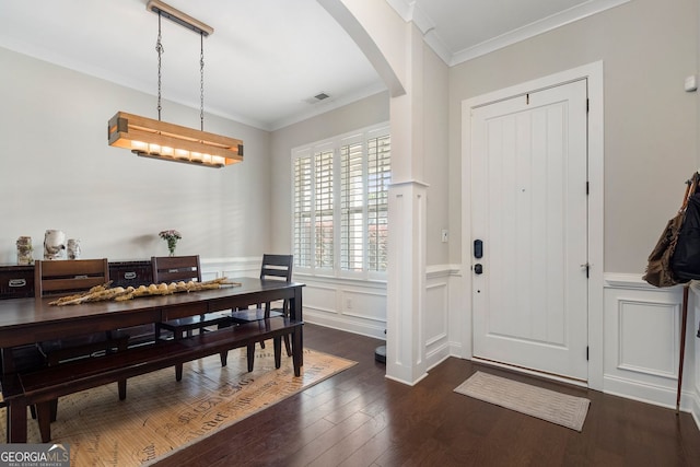 6430 Banbury Ct SE, Mableton, GA 30126 - foyer entrance with arched walkways, dark wood-style flooring, wainscoting, crown molding, and a decorative wall