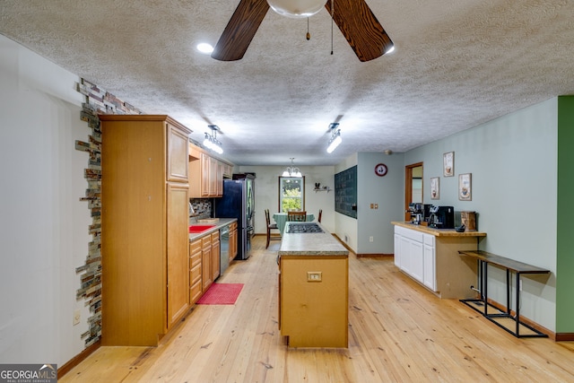 220 Gamble Dr, Carrollton, GA 30116 - kitchen featuring stainless steel appliances, a kitchen island, light wood-style flooring, light countertops, and a textured ceiling
